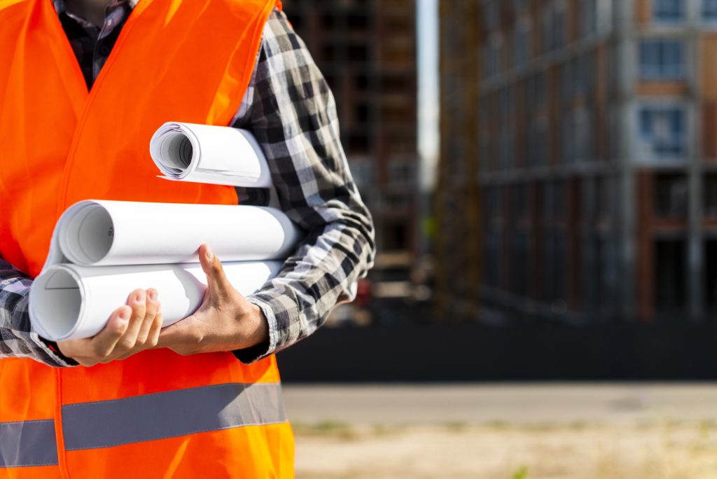 Travailleur de la construction avec des plans de projet